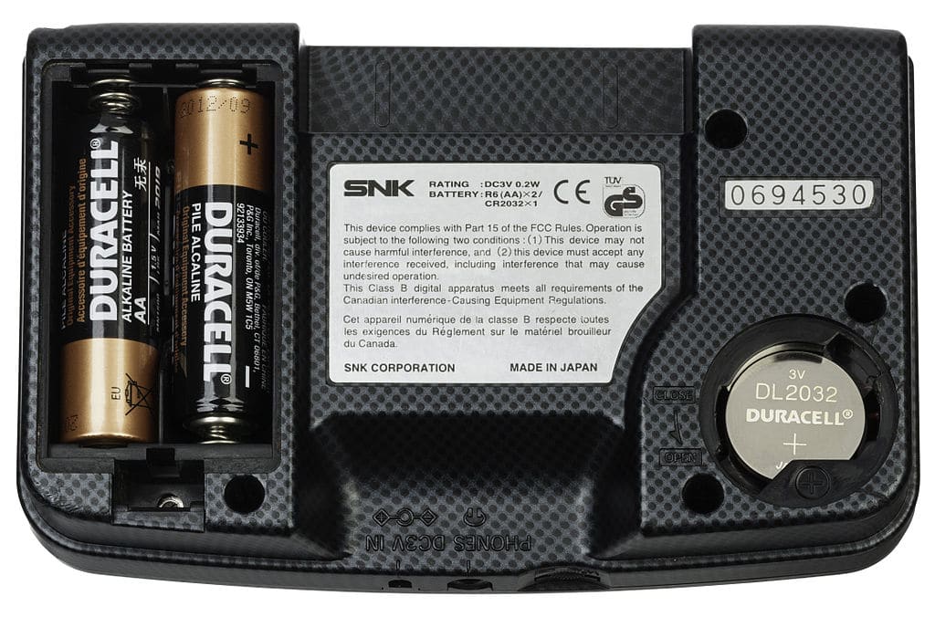 The back of a Neo Geo Pocket Color, a handheld gaming console released by SNK in 1999. This picture shows the both battery compartment covers removed and with batteries inserted. The Pocket Color uses two AA batteries for gameplay and one 2032 button cell battery for an internal clock. - Photo Credit: Evan Amos via Wikimedia.org